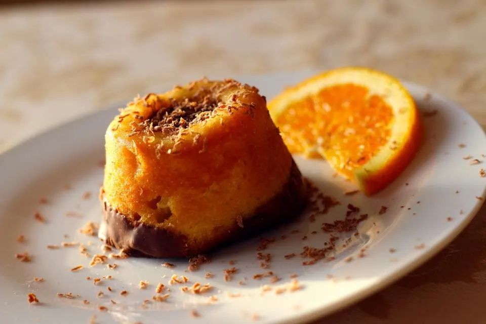 Bizcocho individual de naranja con una rodaja de naranja al lado